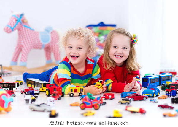 蹒跚学步的男孩和女孩在玩模型车微笑的小孩笑脸笑容